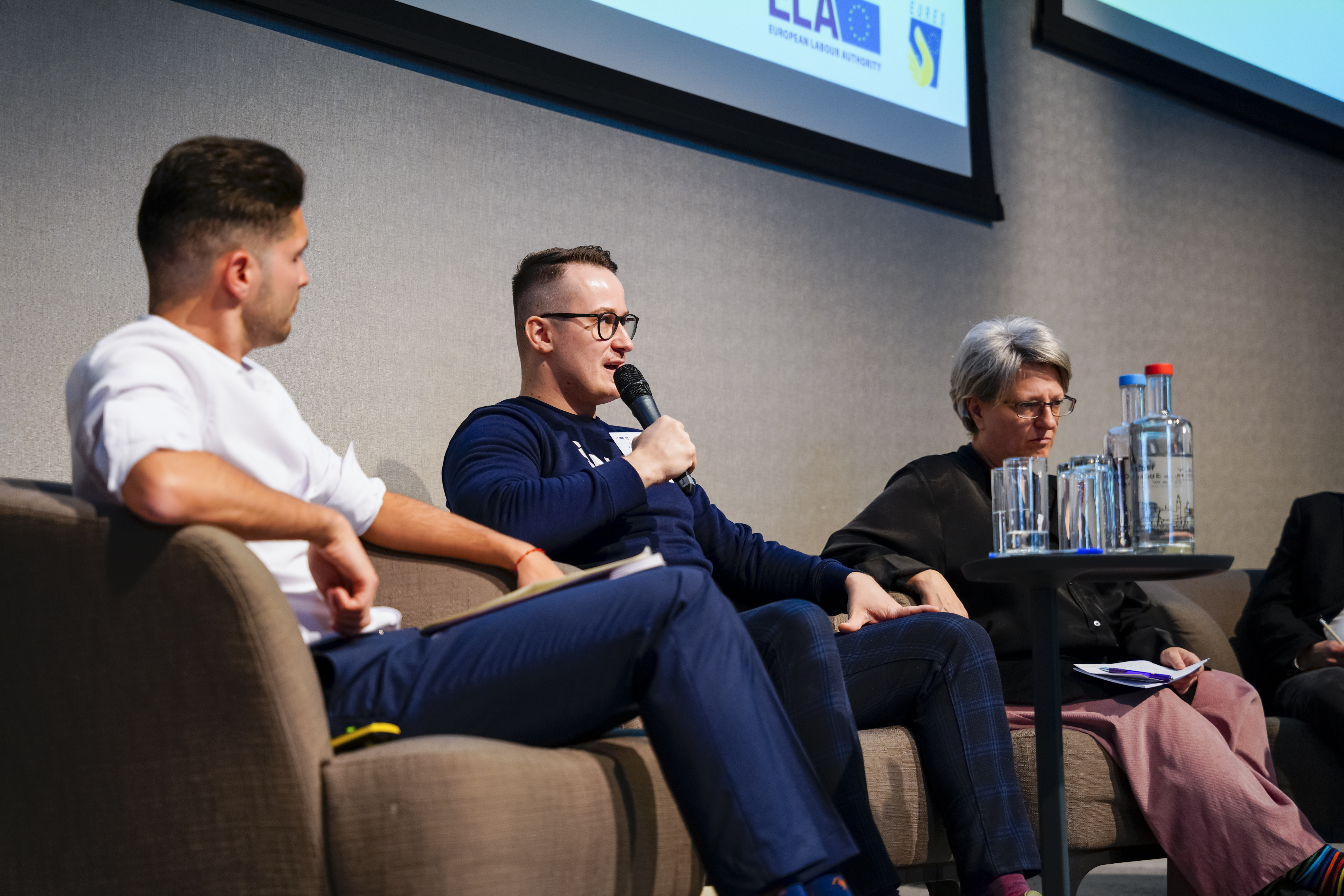 3 persons sitting in a pannel, discussing